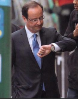 François Hollande regarde sa montre à l'envers. 